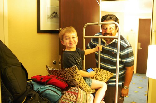 Adam loves to ride the luggage cart.
