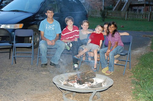 All the kids around the fire making smores.